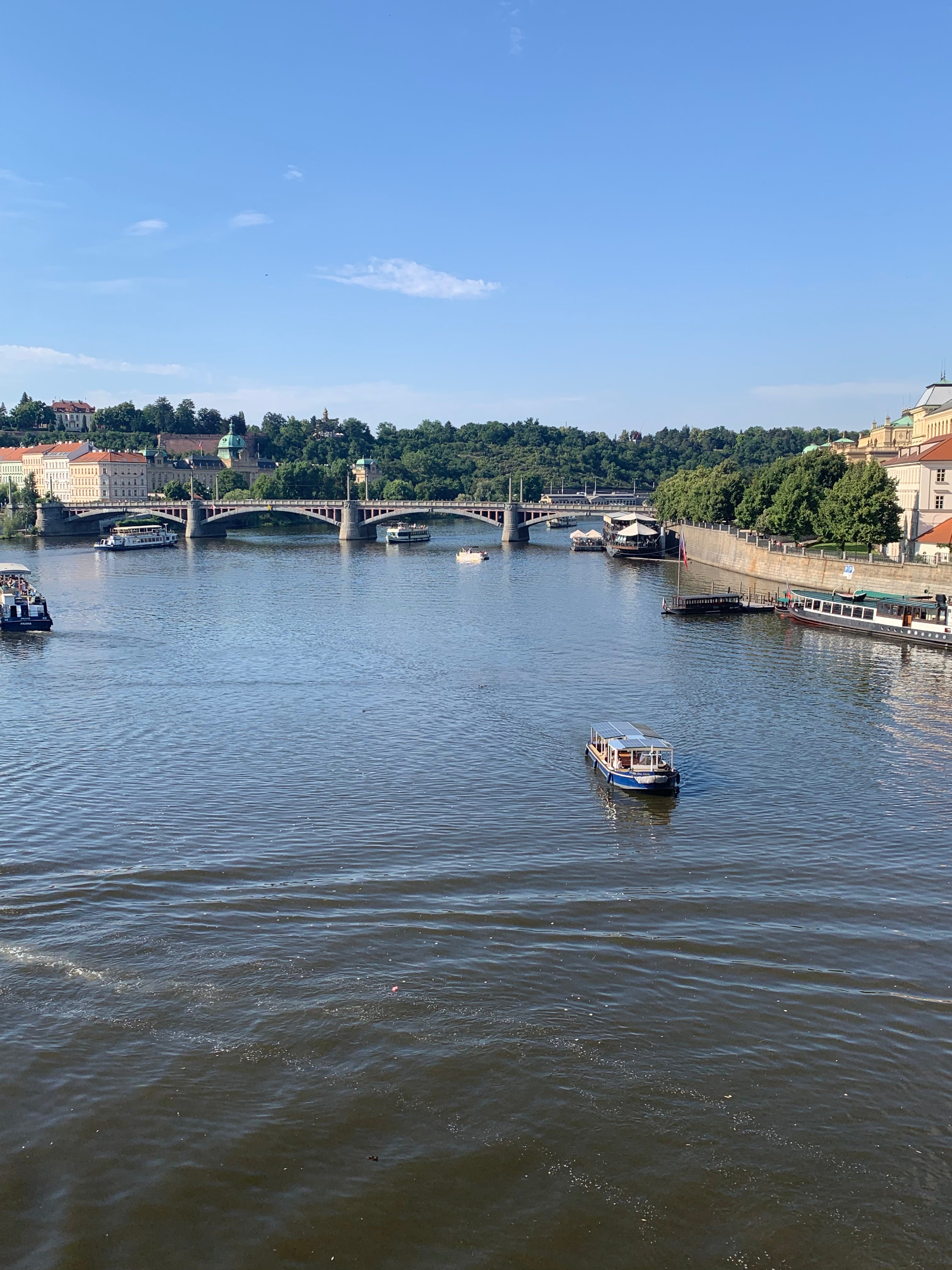 River scene with boats and a bridge under a clear blue sky